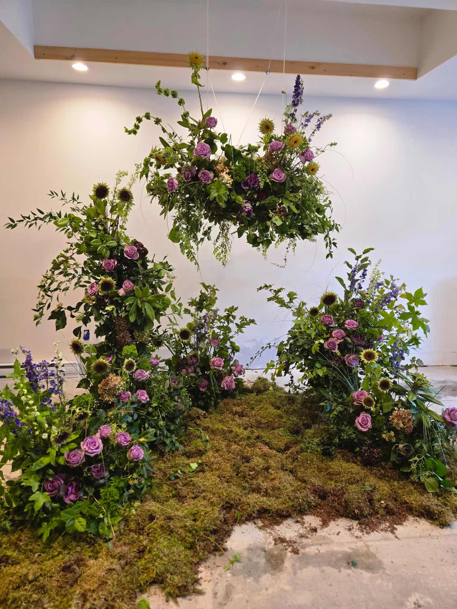 Hanging floral cloud above a moss meadow of lavender roses and sunflowers