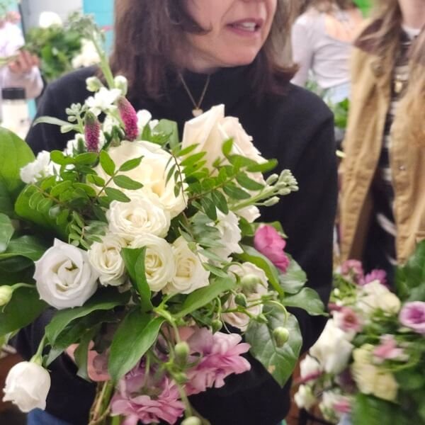 Instructor presenting a finished white rose bouquet