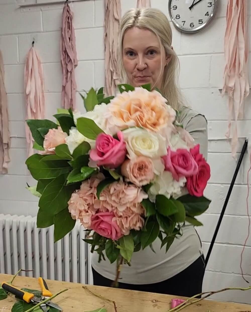 Student holding a finished spiral tied bouquet
