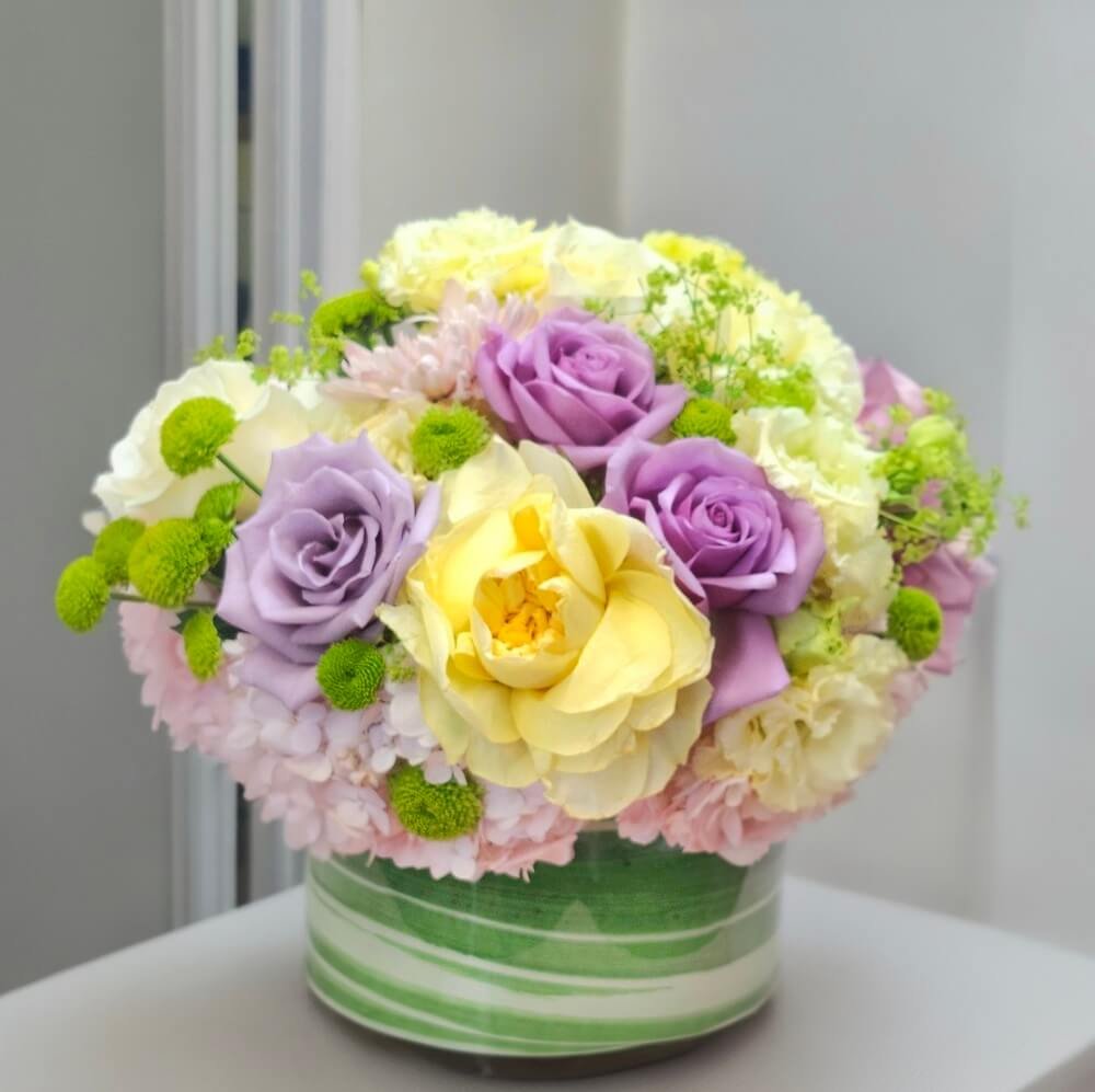 Finished packed vase centerpiece of lavender roses and hydrangeas
